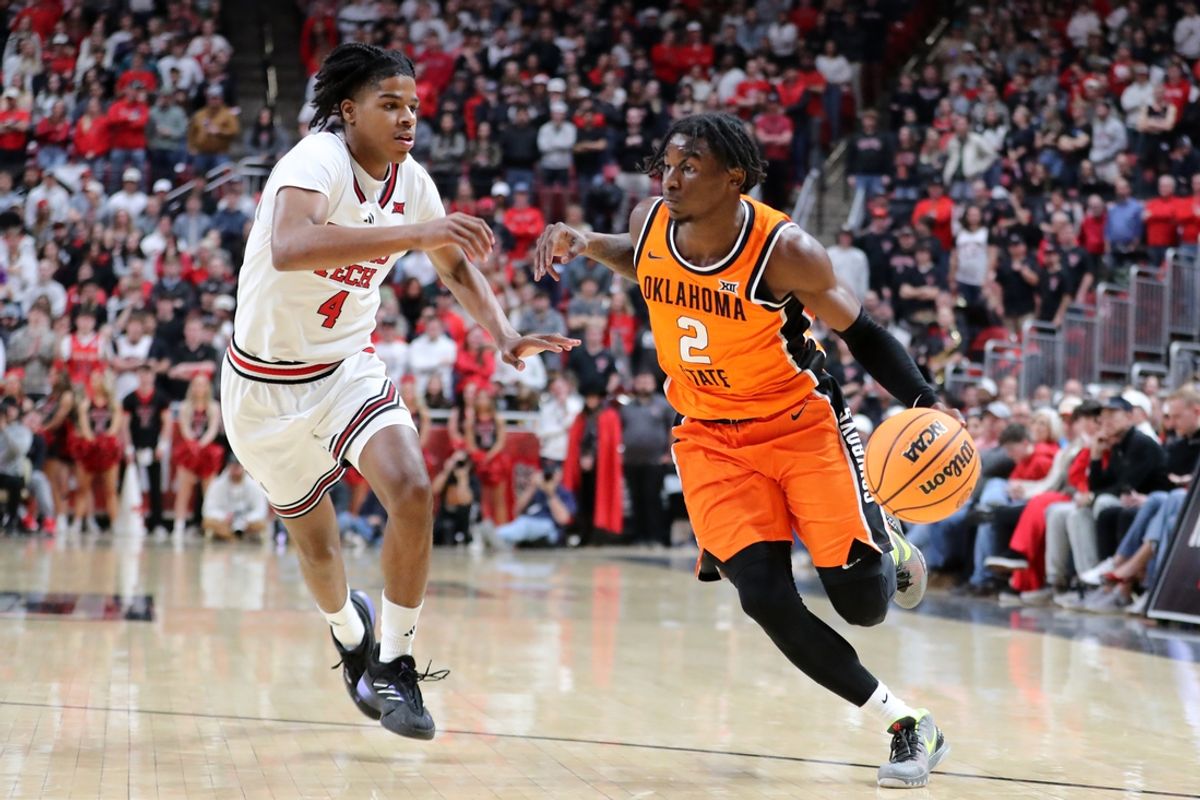 Jan 26, 2025; Lubbock, Texas, USA;  Oklahoma State Cowboys guard Arturo Dean (2) drives the ball against Texas Tech Red Raiders guard Christian Anderson (4) in the first half at United Supermarkets Arena. Mandatory Credit: Michael C. Johnson-Imagn Images