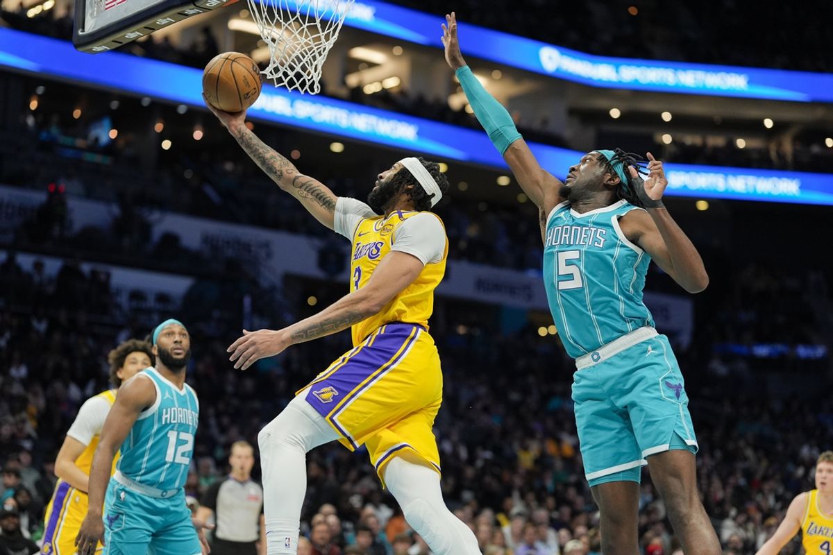 Jan 27, 2025; Charlotte, North Carolina, USA; Los Angeles Lakers forward Anthony Davis (3) makes a layup over Charlotte Hornets center Mark Williams (5) and forward Josh Okogie (12) during the first quarter at the Spectrum Center. Mandatory Credit: Jim Dedmon-Imagn Images
