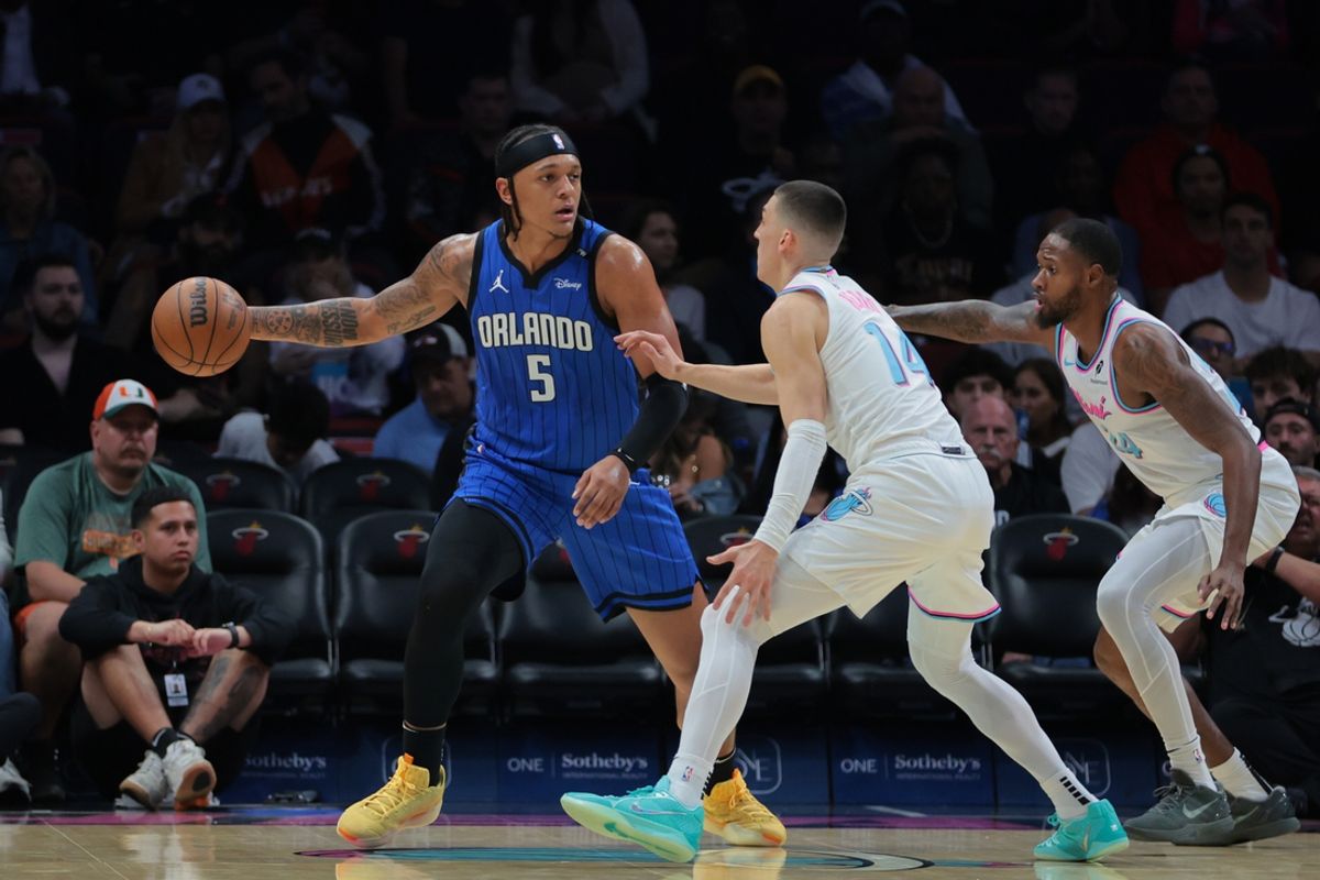 Jan 27, 2025; Miami, Florida, USA; Orlando Magic forward Paolo Banchero (5) protects the basketball from Miami Heat guard Tyler Herro (14) and forward Haywood Highsmith (24) during the first quarter at Kaseya Center. Mandatory Credit: Sam Navarro-Imagn Images