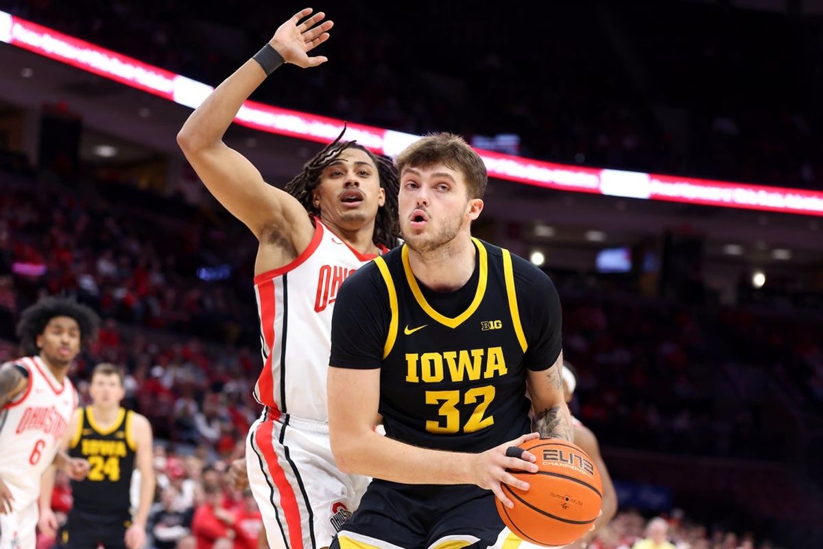 Jan 27, 2025; Columbus, Ohio, USA;  Iowa Hawkeyes forward Owen Freeman (32) controls the ball as Ohio State Buckeyes forward Devin Royal (21) defends during the first half at Value City Arena. Mandatory Credit: Joseph Maiorana-Imagn Images