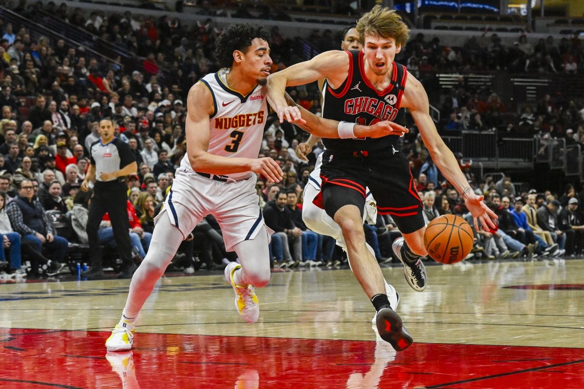 Jan 27, 2025; Chicago, Illinois, USA;  Chicago Bulls forward Matas Buzelis (14) dribbles against Denver Nuggets guard Julian Strawther (3) during the first half at the United Center. Mandatory Credit: Matt Marton-Imagn Images