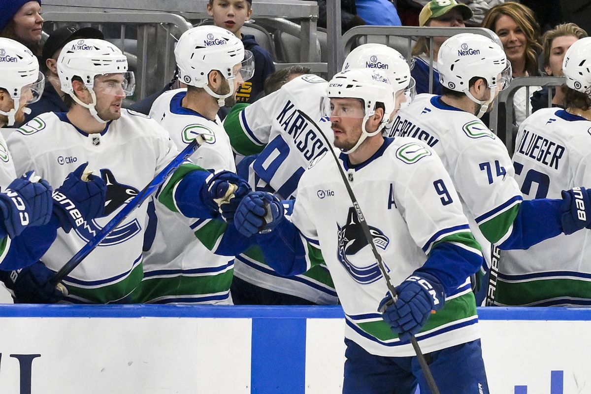 Jan 27, 2025; St. Louis, Missouri, USA;  Vancouver Canucks center J.T. Miller (9) is congratulated by teammates after scoring against the St. Louis Blues during the second period at Enterprise Center. Mandatory Credit: Jeff Curry-Imagn Images