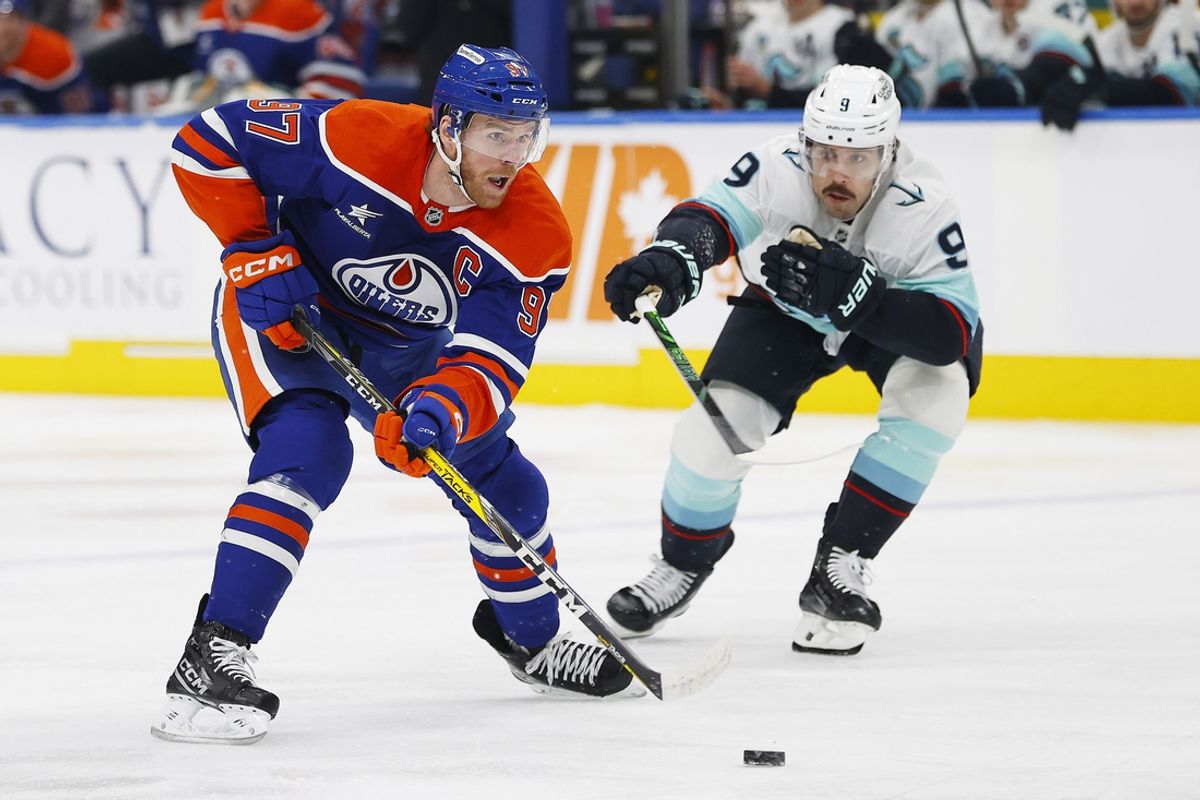 Jan 27, 2025; Edmonton, Alberta, CAN; Seattle Kraken forward Chandler Stephenson (9) tries to knock the puck away from Edmonton Oilers forward Connor McDavid (97) during the first period at Rogers Place. Mandatory Credit: Perry Nelson-Imagn Images