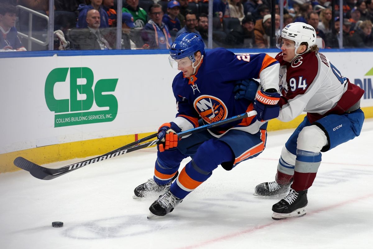Jan 28, 2025; Elmont, New York, USA; New York Islanders defenseman Scott Mayfield (24) fights for the puck against Colorado Avalanche left wing Joel Kiviranta (94) during the first period at UBS Arena. Mandatory Credit: Brad Penner-Imagn Images