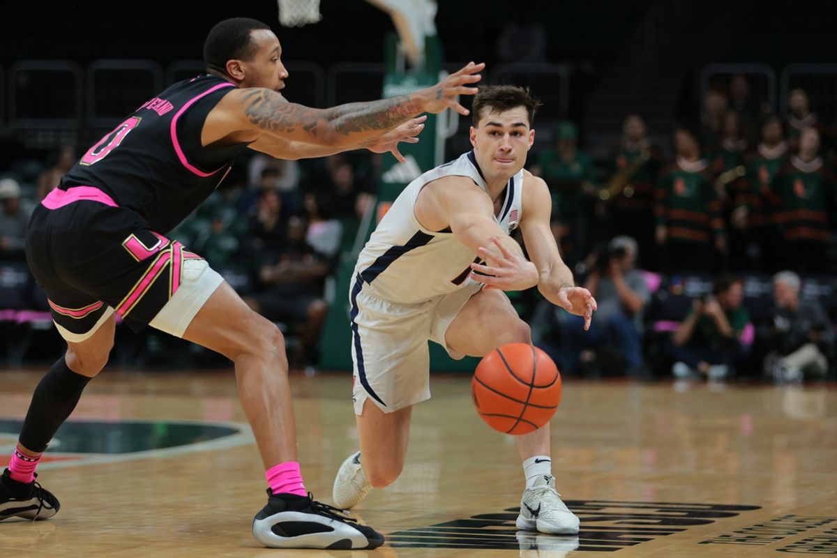 Jan 29, 2025; Coral Gables, Florida, USA; Virginia Cavaliers guard Taine Murray (10) passes the basketball as Miami Hurricanes guard Matthew Cleveland (0) defends during the first half at Watsco Center. Mandatory Credit: Sam Navarro-Imagn Images