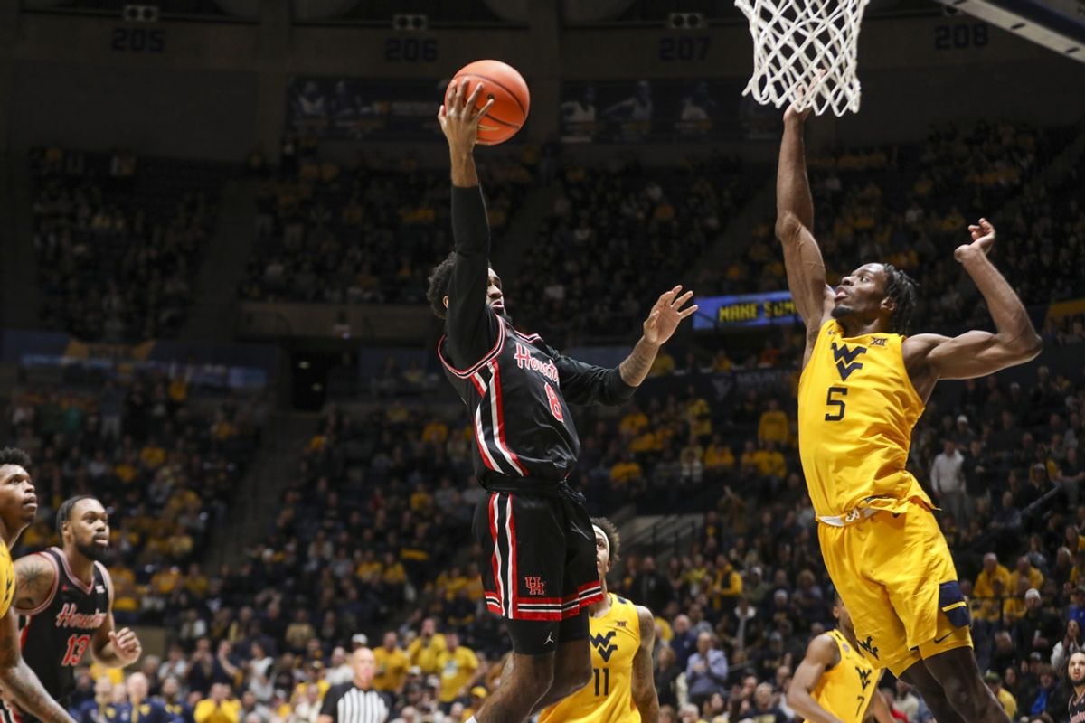 Jan 29, 2025; Morgantown, West Virginia, USA; Houston Cougars guard Mylik Wilson (8) shoots in the lane over West Virginia Mountaineers guard Toby Okani (5) during the second half at WVU Coliseum. Mandatory Credit: Ben Queen-Imagn Images