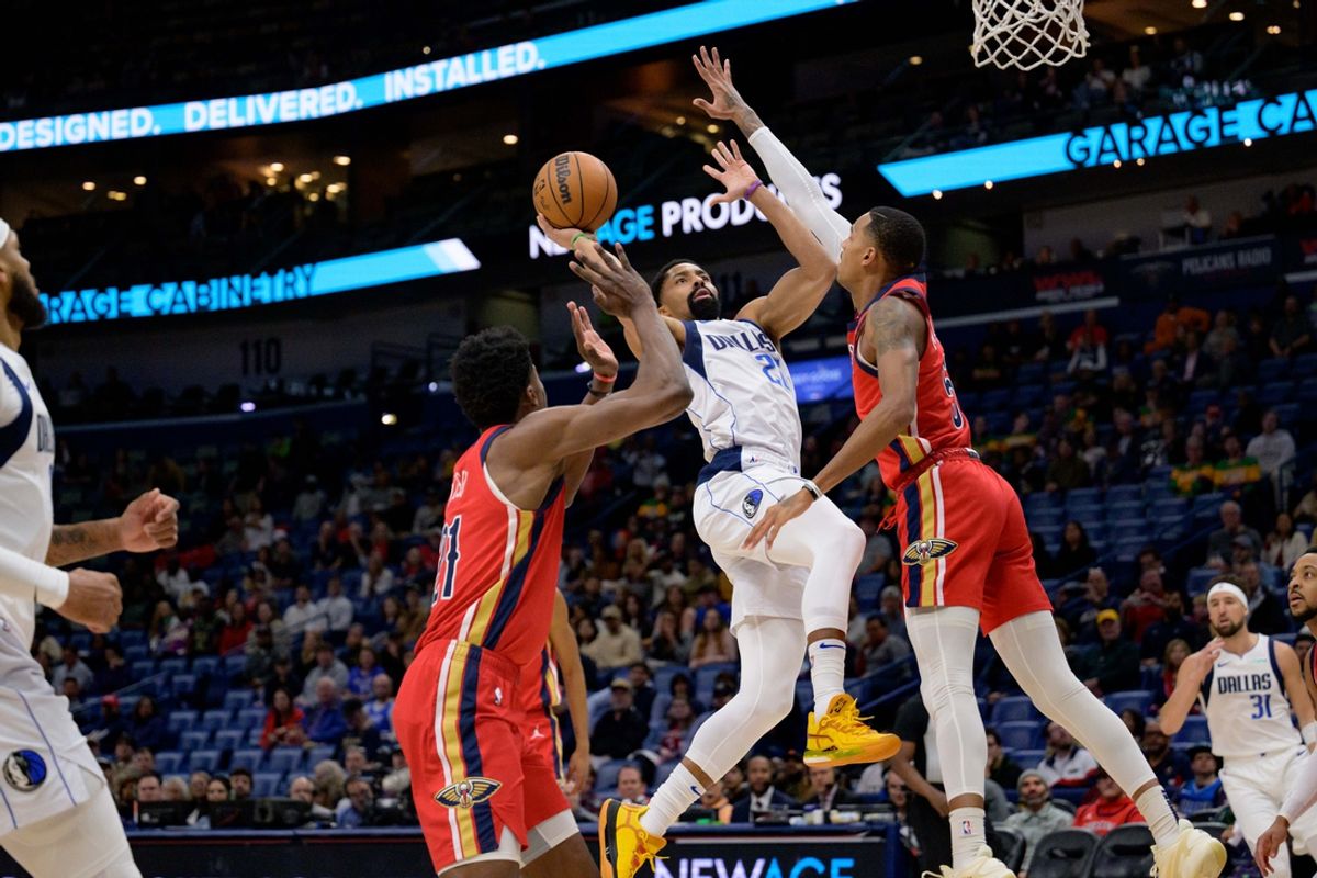 Jan 29, 2025; New Orleans, Louisiana, USA; Dallas Mavericks guard Spencer Dinwiddie (26) shoots against New Orleans Pelicans center Yves Missi (21) and guard Dejounte Murray (5) during the first half at Smoothie King Center. Mandatory Credit: Matthew Hinton-Imagn Images