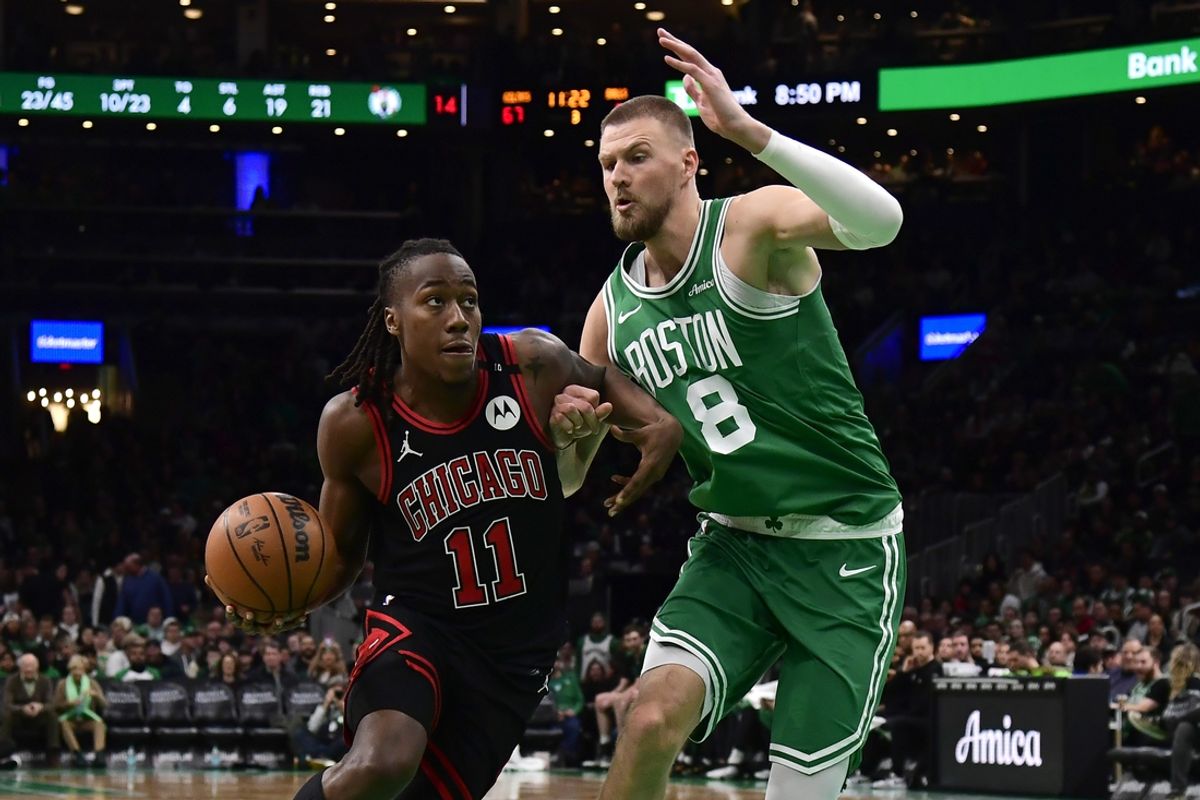 Jan 29, 2025; Boston, Massachusetts, USA; Chicago Bulls guard Ayo Dosunmu (11) controls the ball while Boston Celtics center Kristaps Porzingis (8) defends during the second half at TD Garden. Mandatory Credit: Bob DeChiara-Imagn Images