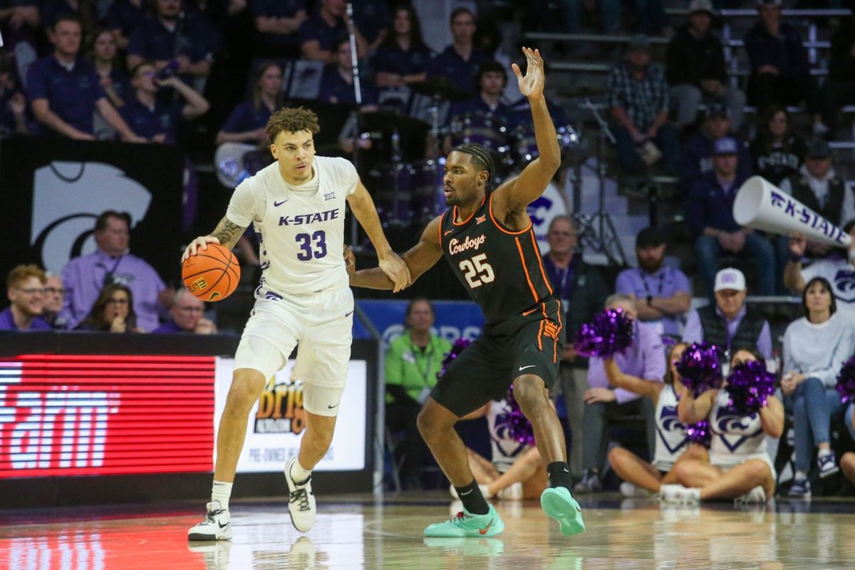 Jan 29, 2025; Manhattan, Kansas, USA; Kansas State Wildcats forward Coleman Hawkins (33) dribbles against Oklahoma State Cowboys forward Robert Jennings II (25) during the first half at Bramlage Coliseum. Mandatory Credit: Scott Sewell-Imagn Images