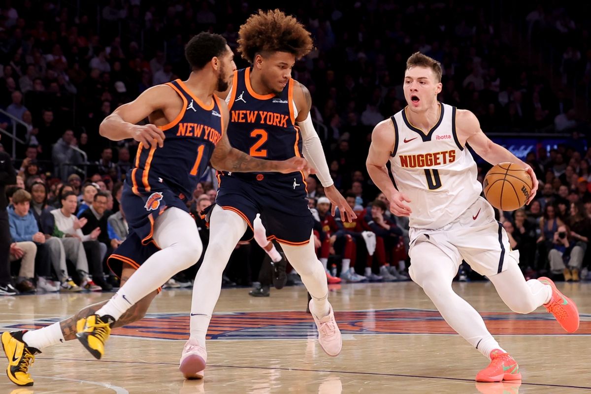 Jan 29, 2025; New York, New York, USA; Denver Nuggets guard Christian Braun (0) drives to the basket against New York Knicks guards Cameron Payne (1) and Miles McBride (2) during the fourth quarter at Madison Square Garden. Mandatory Credit: Brad Penner-Imagn Images
