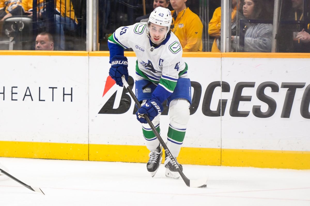Jan 29, 2025; Nashville, Tennessee, USA;  Vancouver Canucks defenseman Quinn Hughes (43) skates behind the net against the Nashville Predators during the third period at Bridgestone Arena. Mandatory Credit: Steve Roberts-Imagn Images