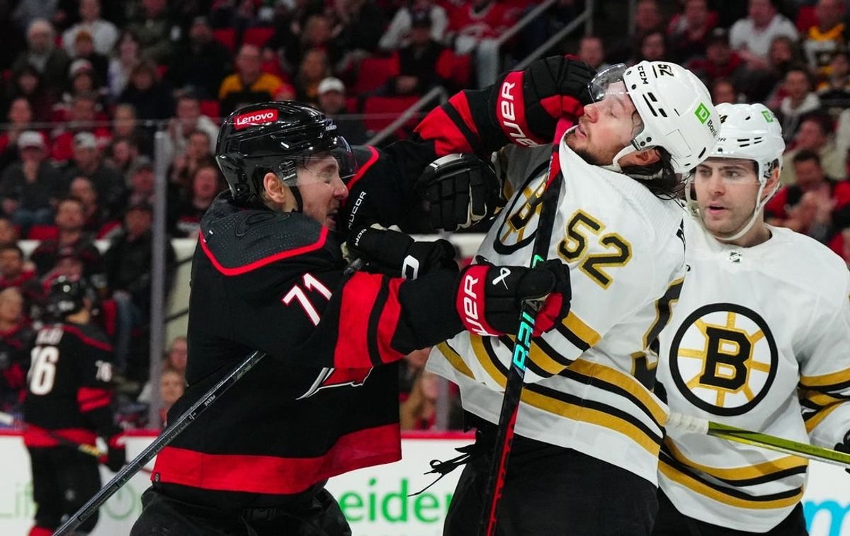 Apr 4, 2024; Raleigh, North Carolina, USA; Carolina Hurricanes right wing Jesper Fast (71) and Boston Bruins defenseman Andrew Peeke (52) battle during the third period at PNC Arena.