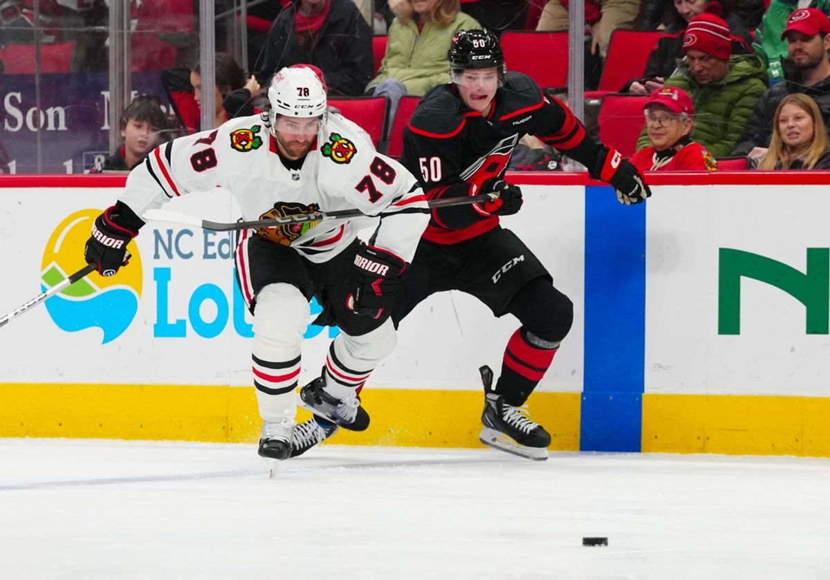 Jan 30, 2025; Raleigh, North Carolina, USA;  Carolina Hurricanes left wing Eric Robinson (50) and Chicago Blackhawks defenseman TJ Brodie (78) watch the puck during the first period at Lenovo Center. Mandatory Credit: James Guillory-Imagn Images