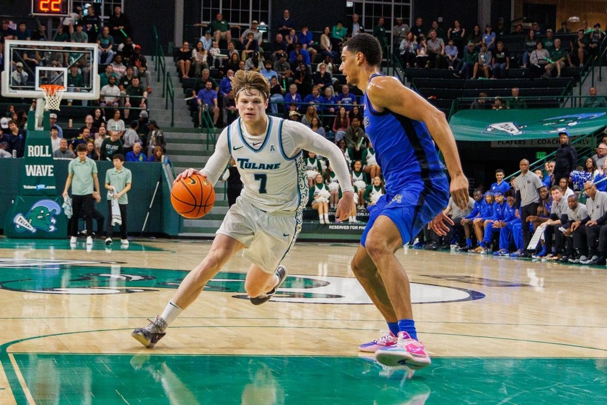 Jan 30, 2025; New Orleans, Louisiana, USA;  Tulane Green Wave guard Rowan Brumbaugh (7) dribbles against Memphis Tigers forward Nicholas Jourdain (2) during the second half at Avron B. Fogelman Arena in Devlin Fieldhouse. Mandatory Credit: Stephen Lew-Imagn Images