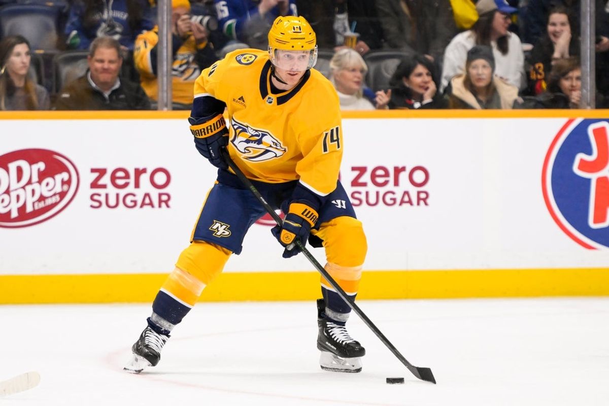 Jan 29, 2025; Nashville, Tennessee, USA;  Nashville Predators center Gustav Nyquist (14) skates with the puck against the Vancouver Canucks during the first period at Bridgestone Arena. Mandatory Credit: Steve Roberts-Imagn Images