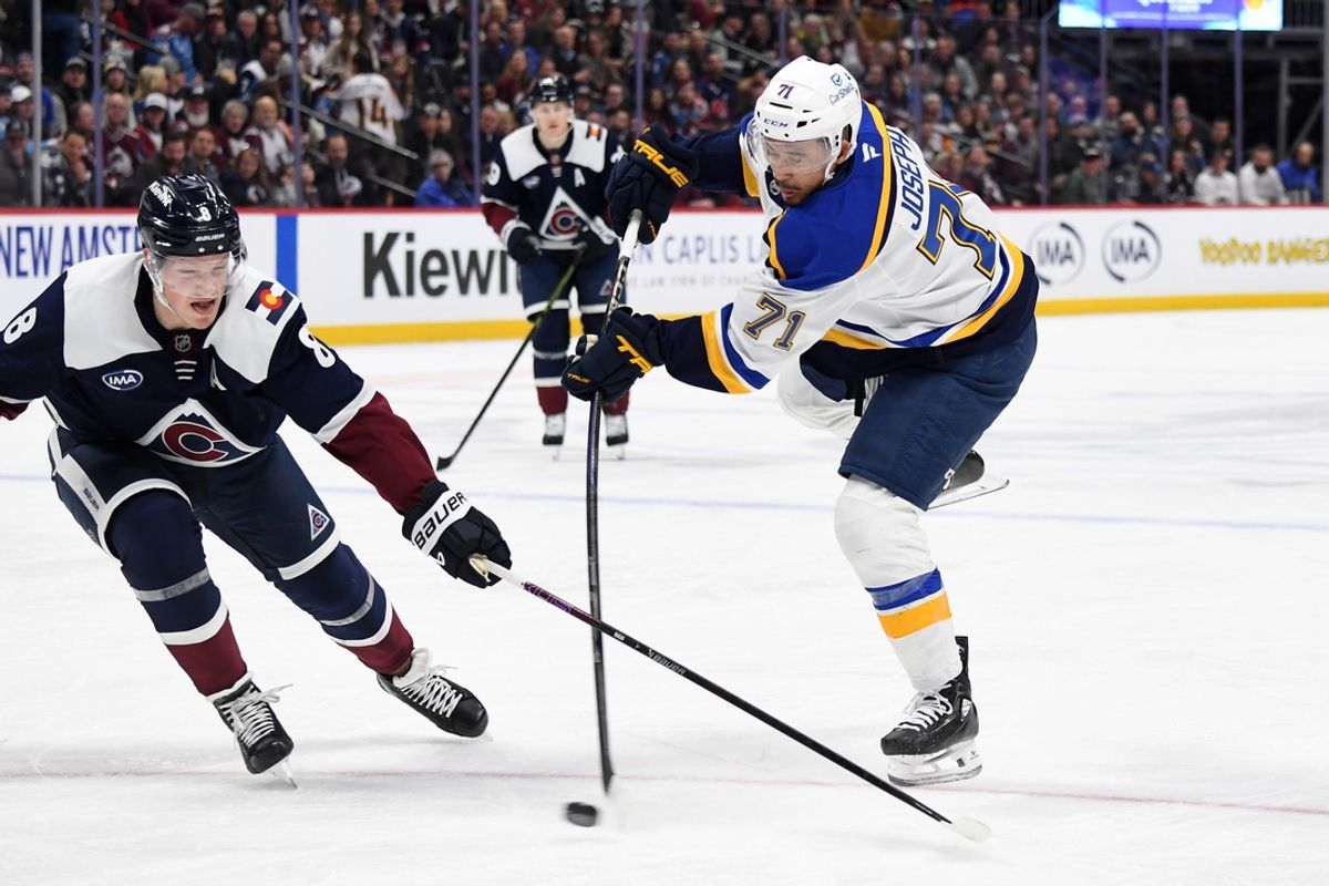 Jan 31, 2025; Denver, Colorado, USA; St. Louis Blues right wing Mathieu Joseph (71) shoots against Colorado Avalanche defenseman Cale Makar (8) during the first period at Ball Arena. Mandatory Credit: Christopher Hanewinckel-Imagn Images