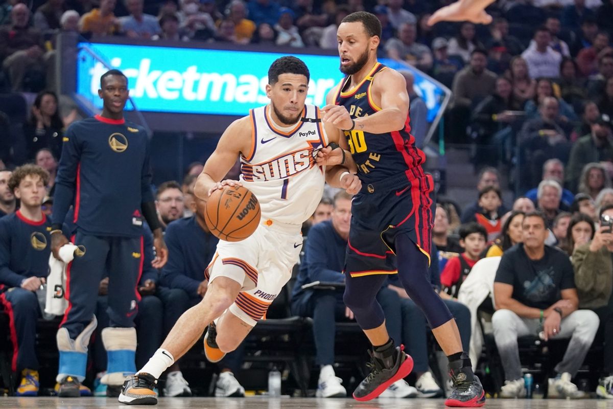 Jan 31, 2025; San Francisco, California, USA; Phoenix Suns guard Devin Booker (1) dribbles next to Golden State Warriors guard Stephen Curry (30) in the first quarter at the Chase Center. Mandatory Credit: Cary Edmondson-Imagn Images