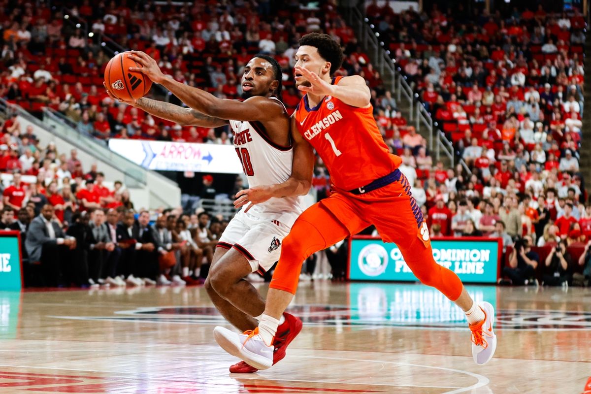 Feb 1, 2025; Raleigh, North Carolina, USA; North Carolina State Wolfpack guard Marcus Hill (10) dribbles with the ball guarded by Clemson Tigers guard Chase Hunter (1) during the first half of the game at Lenovo Center. Mandatory Credit: Jaylynn Nash-Imagn Images