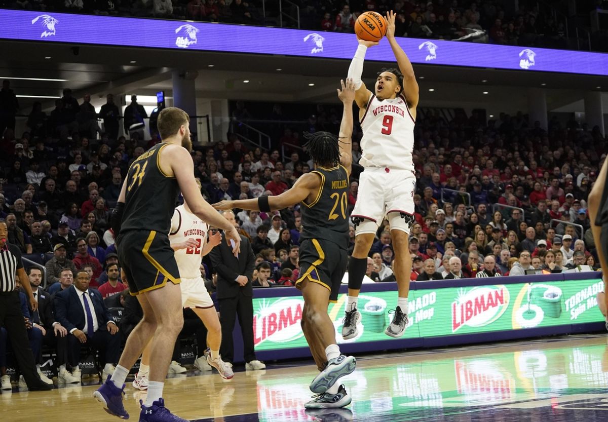 Feb 1, 2025; Evanston, Illinois, USA; Wisconsin Badgers guard John Tonje (9) shoots a three point basket as Northwestern Wildcats guard Justin Mullins (20) defends him during the first half at Welsh-Ryan Arena. Mandatory Credit: David Banks-Imagn Images