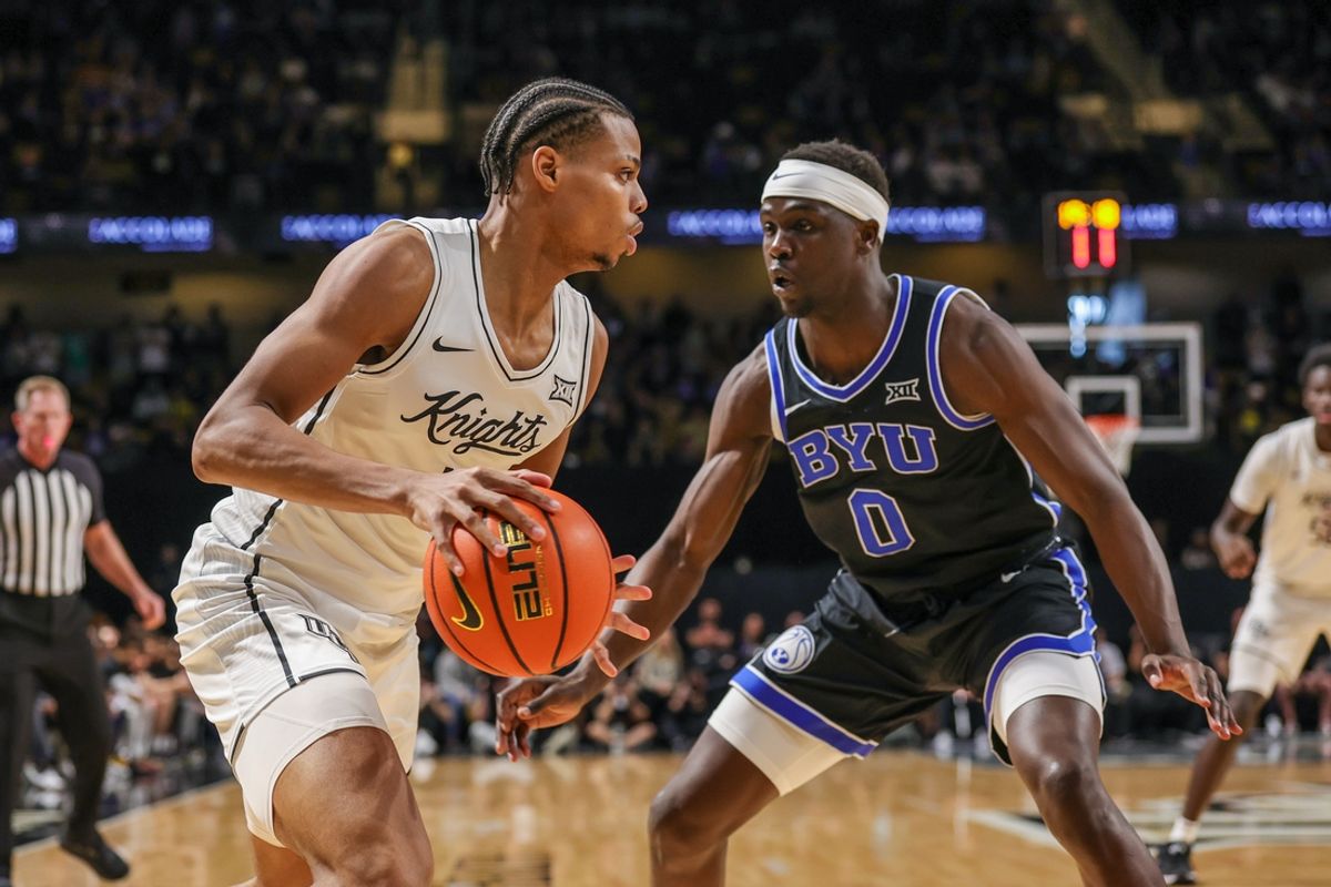 Feb 1, 2025; Orlando, Florida, USA; UCF Knights guard Keyshawn Hall (4) handles the ball in front of Brigham Young Cougars forward Mawot Mag (0) during the first half at Addition Financial Arena. Mandatory Credit: Mike Watters-Imagn Images