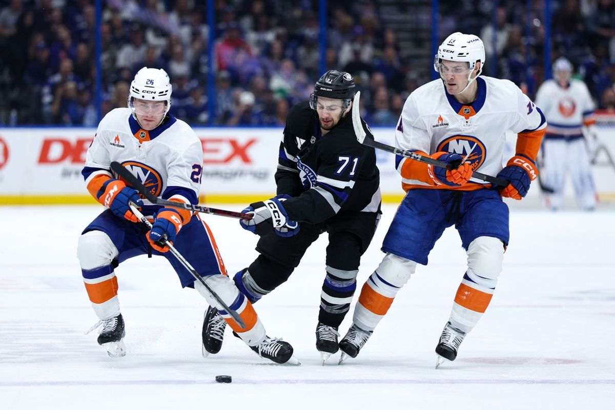 Feb 1, 2025; Tampa, Florida, USA; New York Islanders defenseman Scott Perunovich (26) and Tampa Bay Lightning center Anthony Cirelli (71) battle for the puck in thfirst period at Amalie Arena. Mandatory Credit: Nathan Ray Seebeck-Imagn Images
