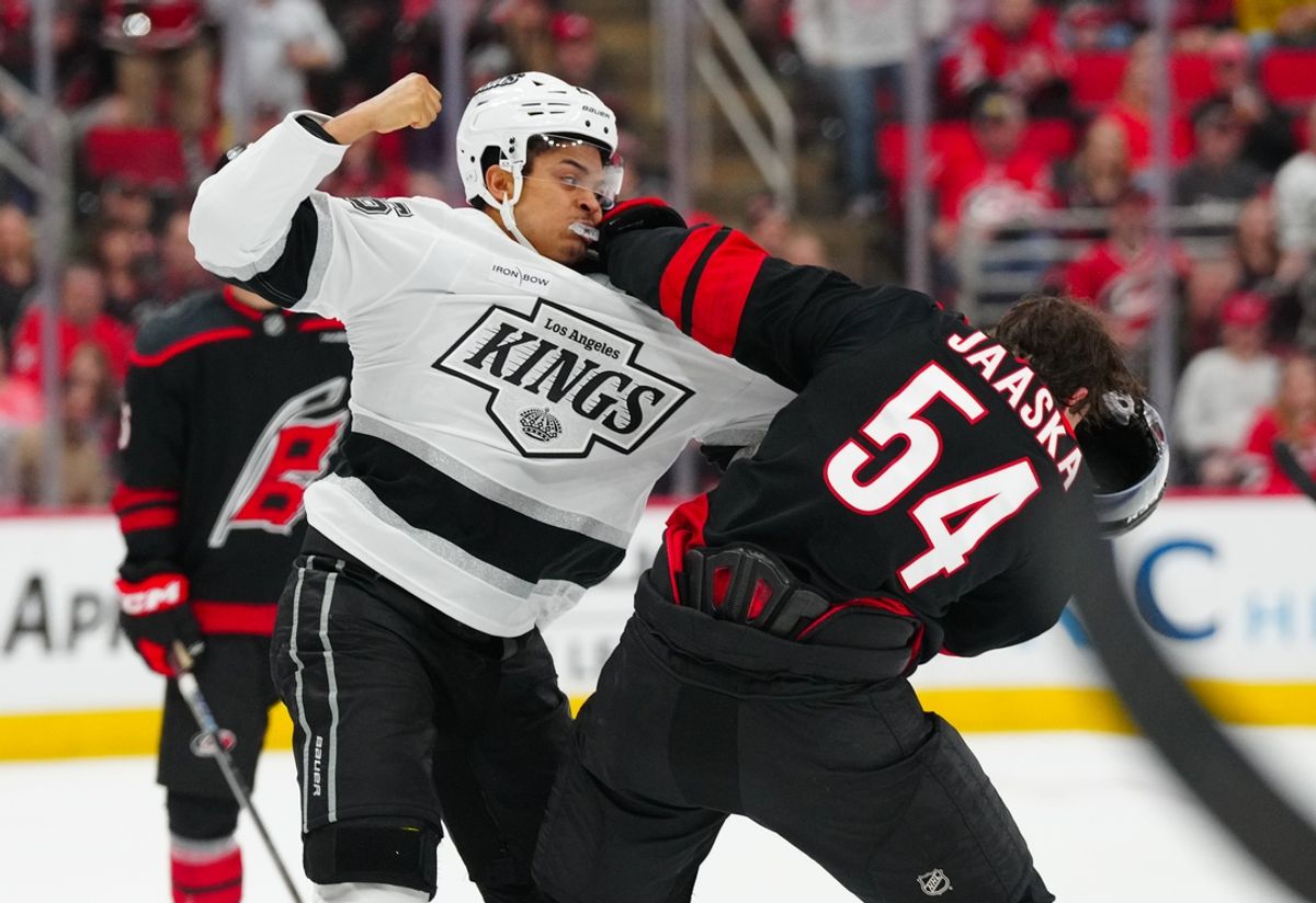Feb 1, 2025; Raleigh, North Carolina, USA;  Carolina Hurricanes left wing Juha Jaaska (54) fights Los Angeles Kings center Akil Thomas (26) during the first period at Lenovo Center. Mandatory Credit: James Guillory-Imagn Images