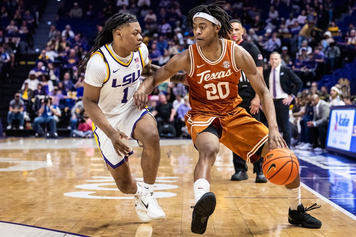 Feb 1, 2025; Baton Rouge, Louisiana, USA;  Texas Longhorns guard Tre Johnson (20) dribbles against LSU Tigers guard Jordan Sears (1) during the second half at Pete Maravich Assembly Center. Mandatory Credit: Stephen Lew-Imagn Images