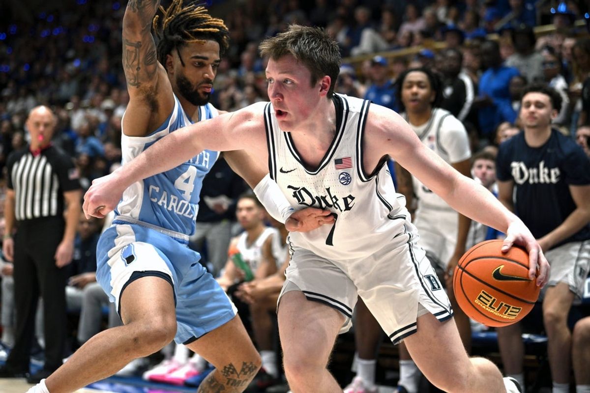 Feb 1, 2025; Durham, North Carolina, USA;  Duke Blue Devils forward Kon Knueppel (7) drives the ball around North Carolina Tar Heels guard R.J. Davis (4) during the second half at Cameron Indoor Stadium. Mandatory Credit: Zachary Taft-Imagn Images