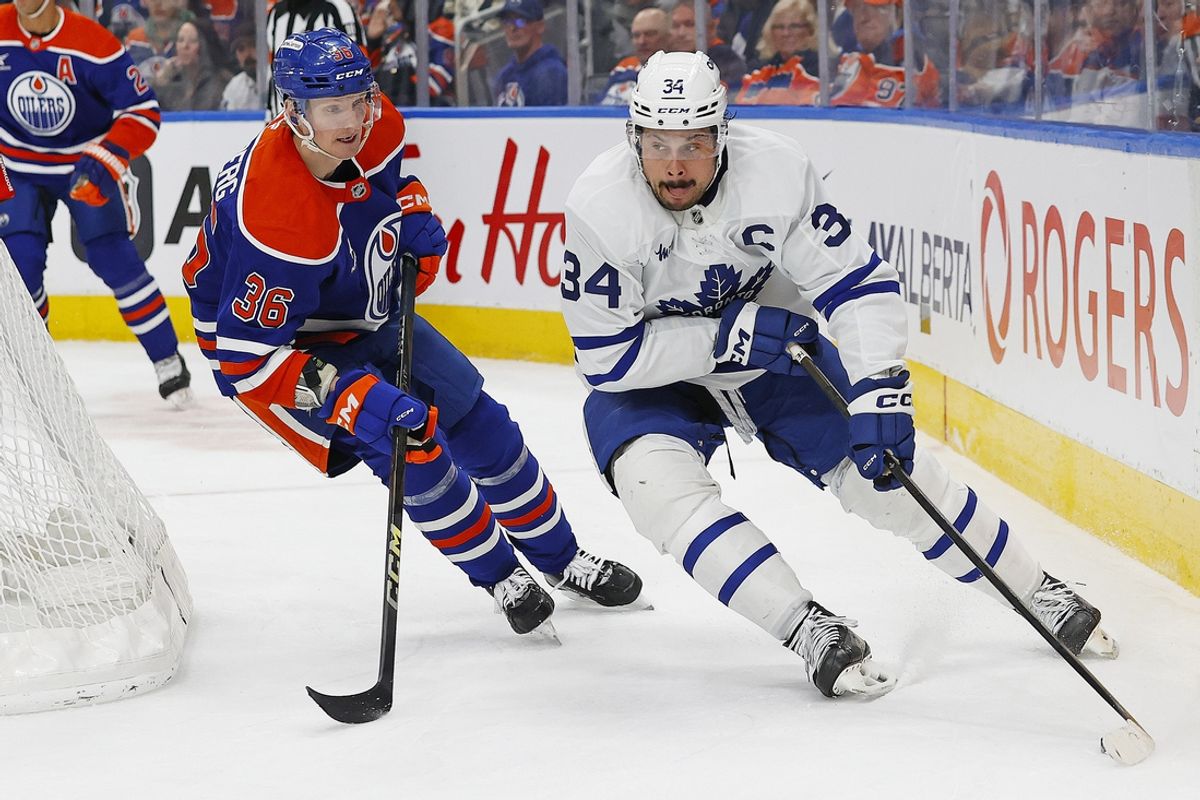 Feb 1, 2025; Edmonton, Alberta, CAN; Toronto Maple Leafs forward Auston Matthews (34) protects the puck from Edmonton Oilers defensemen John Klingberg (36) during the second period at Rogers Place. Mandatory Credit: Perry Nelson-Imagn Images