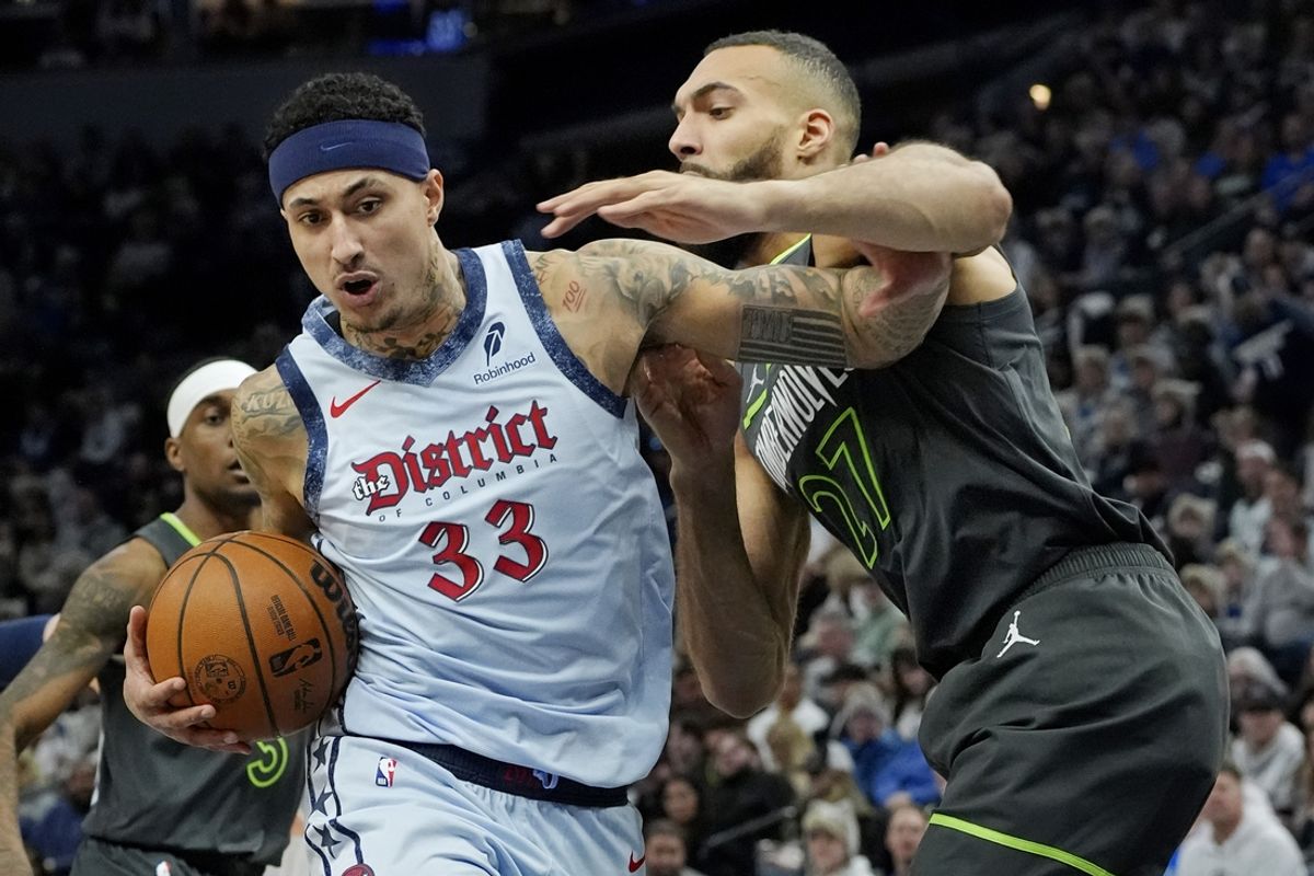 Feb 1, 2025; Minneapolis, Minnesota, USA; Washington Wizards forward Kyle Kuzma (33) goes to the basket against Minnesota Timberwolves center Rudy Gobert (27) in the first quarter at Target Center. Mandatory Credit: Bruce Kluckhohn-Imagn Images