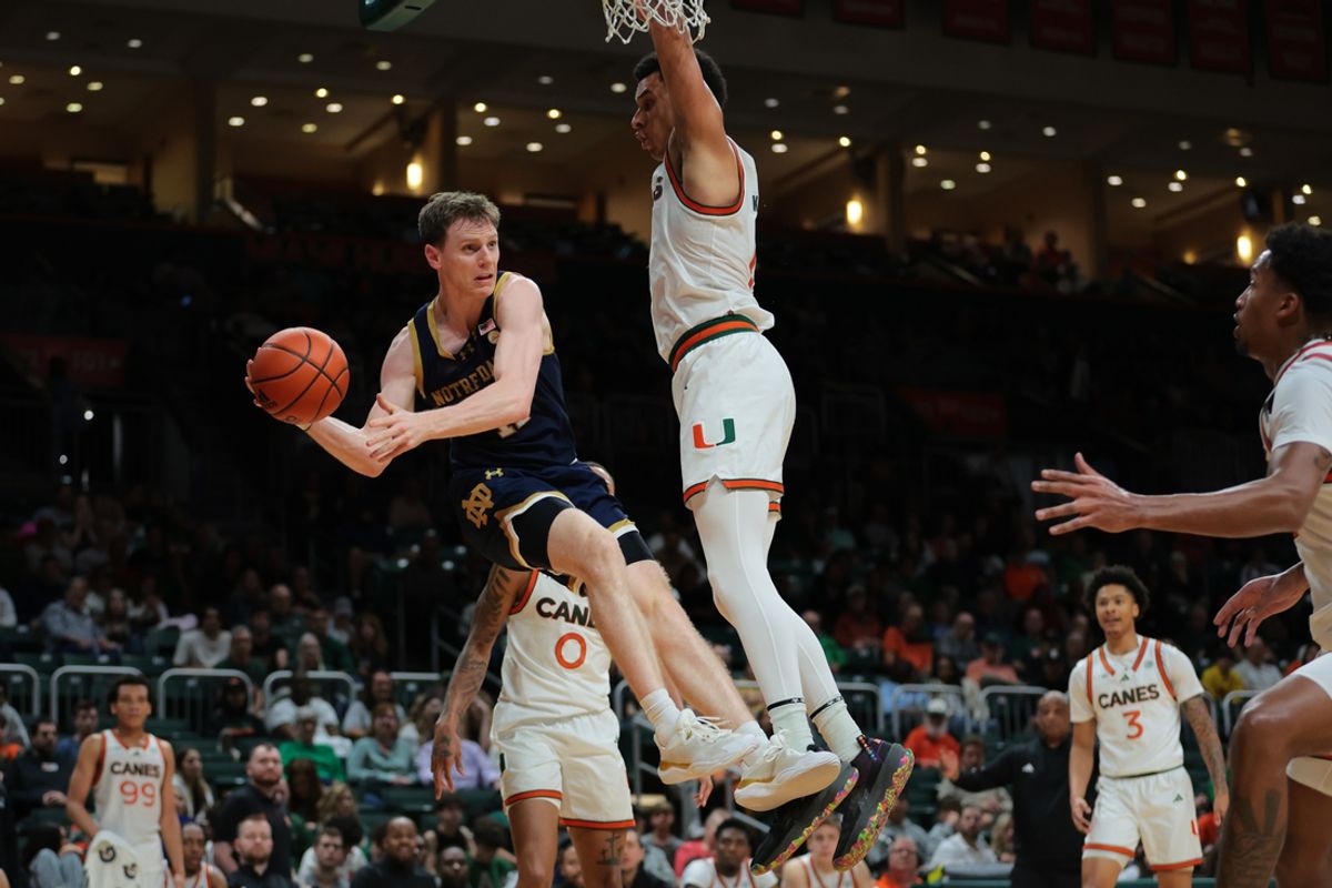 Feb 1, 2025; Coral Gables, Florida, USA; Notre Dame Fighting Irish guard Matt Allocco (41) passes the basket as Miami Hurricanes center Lynn Kidd (1) defends during the first half at Watsco Center. Mandatory Credit: Sam Navarro-Imagn Images