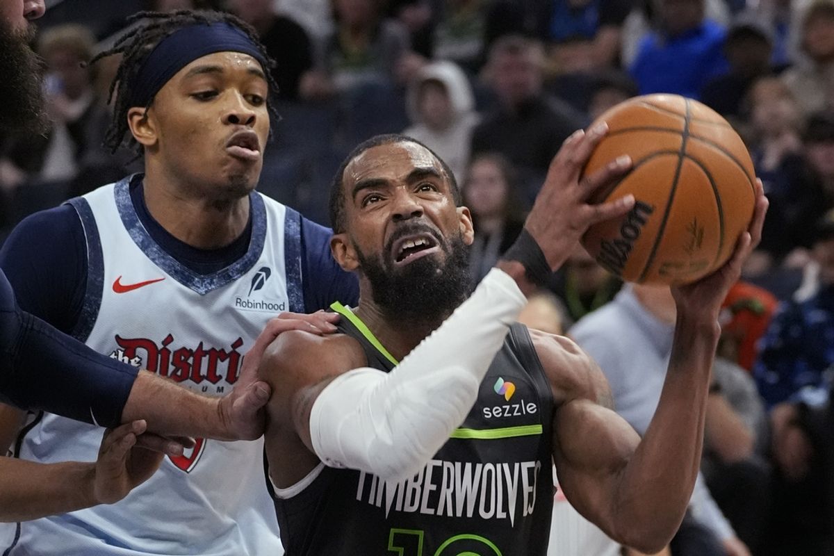 Feb 1, 2025; Minneapolis, Minnesota, USA; Minnesota Timberwolves guard Mike Conley (10) goes to the basket past Washington Wizards guard Carlton Carrington (8) in the fourth quarter at Target Center. Mandatory Credit: Bruce Kluckhohn-Imagn Images