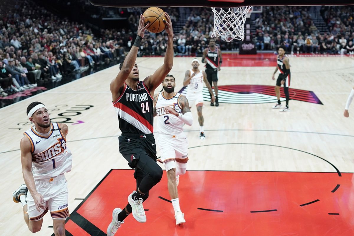 Feb 1, 2025; Portland, Oregon, USA; Portland Trail Blazers forward Kris Murray (24) shoots the ball past Phoenix Suns shooting guard Devin Booker (1) during the first half at Moda Center. Mandatory Credit: Soobum Im-Imagn Images