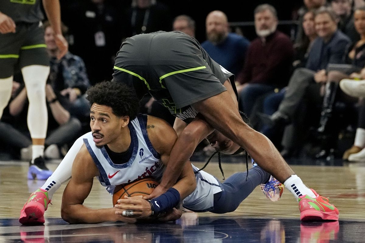 Feb 1, 2025; Minneapolis, Minnesota, USA; Minnesota Timberwolves guard Rob Dillingham (4) goes for the ball against Washington Wizards guard Jordan Poole (13) in the third quarter at Target Center. Mandatory Credit: Bruce Kluckhohn-Imagn Images