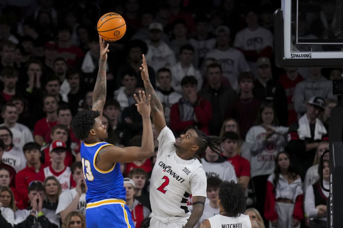 Feb 2, 2025; Cincinnati, Ohio, USA;  West Virginia Mountaineers forward Amani Hansberry (13) shoots against Cincinnati Bearcats guard Jizzle James (2) in the first half at Fifth Third Arena. Mandatory Credit: Aaron Doster-Imagn Images
