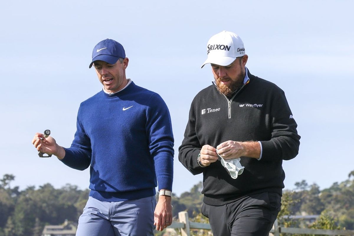 Feb 2, 2025; Pebble Beach, California, USA; Rory McIlroy (left) and Shane Lowry (right) walk on the fifth hole during the final round of the AT&T Pebble Beach Pro-Am golf tournament at Pebble Beach Golf Links. Mandatory Credit: Kiyoshi Mio-Imagn Images