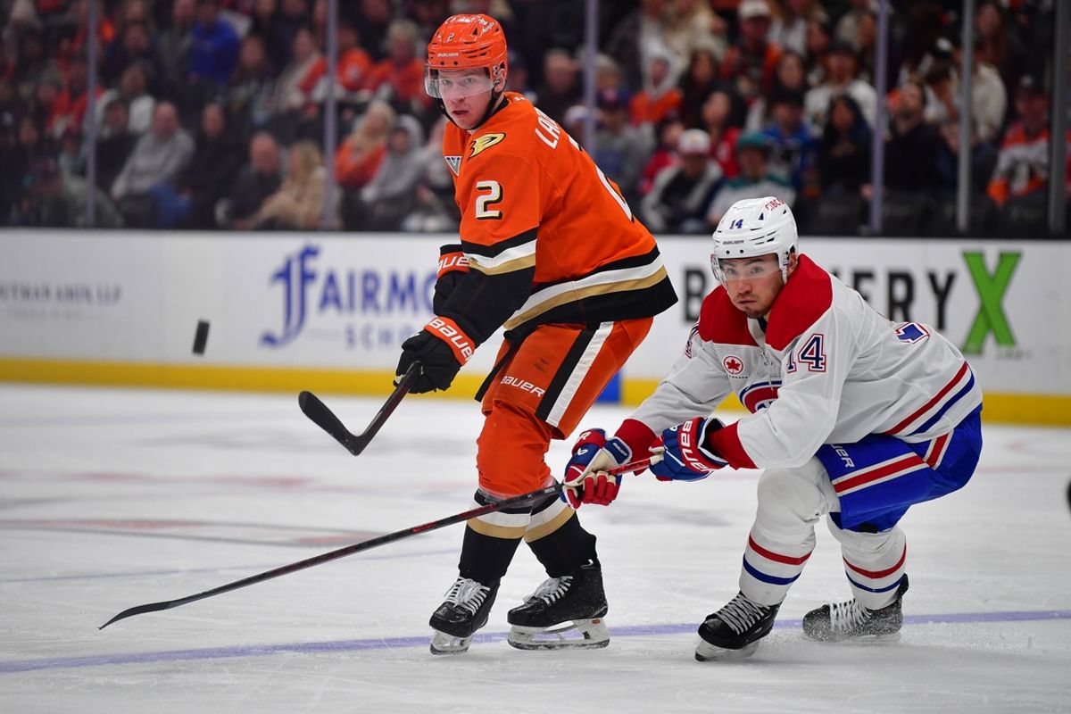 Feb 2, 2025; Anaheim, California, USA; Anaheim Ducks defenseman Jackson LaCombe (2) moves the puck against Montreal Canadiens center Nick Suzuki (14) during the second period at Honda Center. Mandatory Credit: Gary A. Vasquez-Imagn Images