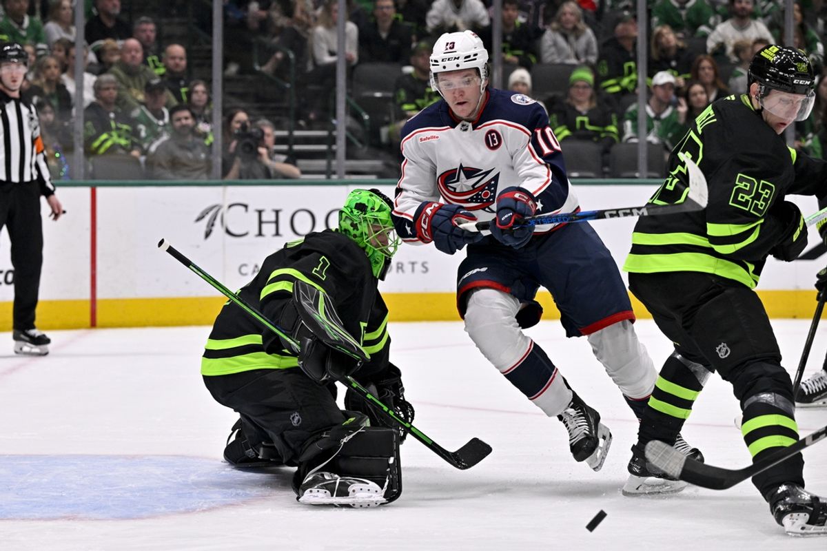 Feb 2, 2025; Dallas, Texas, USA; Columbus Blue Jackets left wing Dmitri Voronkov (10) looks for the puck in front of Dallas Stars goaltender Casey DeSmith (1) during the first period at the American Airlines Center. Mandatory Credit: Jerome Miron-Imagn Images