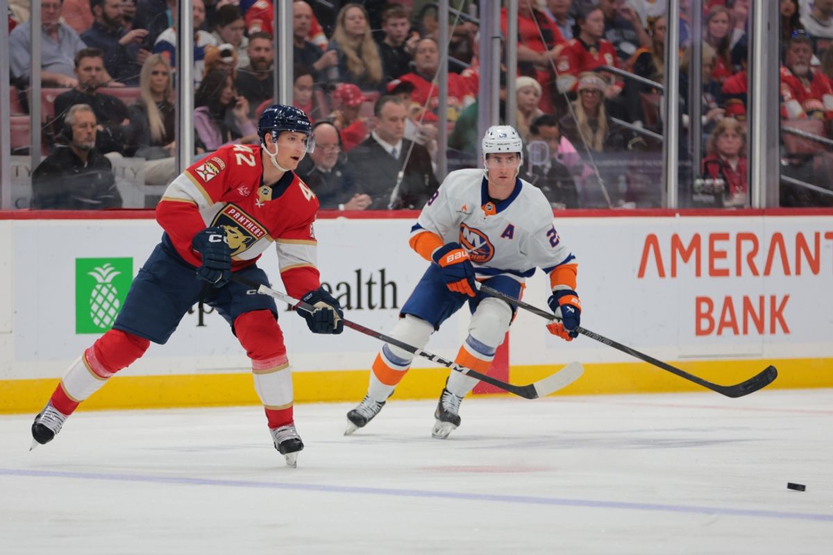 Feb 2, 2025; Sunrise, Florida, USA; Florida Panthers defenseman Gustav Forsling (42) passes the puck as New York Islanders center Brock Nelson (29) defends during the first period at Amerant Bank Arena. Mandatory Credit: Sam Navarro-Imagn Images