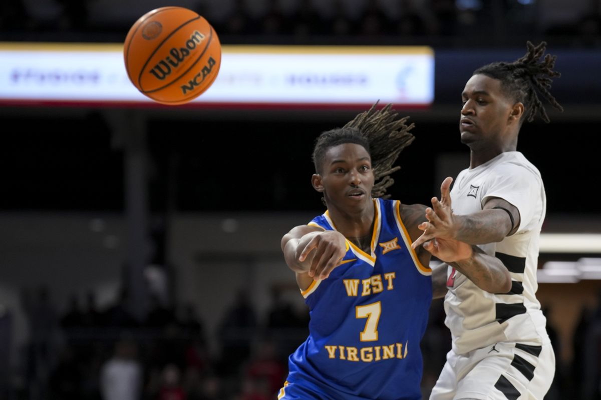 Feb 2, 2025; Cincinnati, Ohio, USA;  West Virginia Mountaineers guard Javon Small (7) passes the ball against Cincinnati Bearcats guard Jizzle James (2) in the second half at Fifth Third Arena. Mandatory Credit: Aaron Doster-Imagn Images
