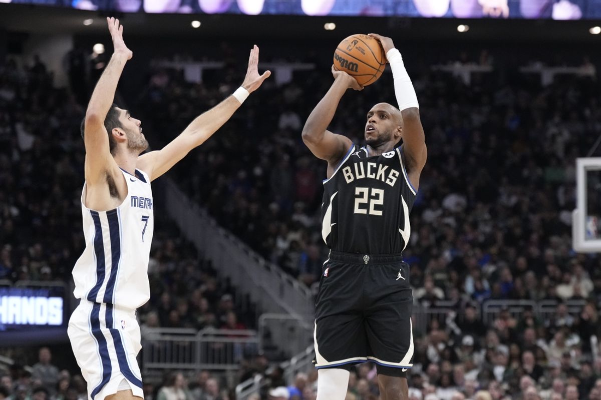 Feb 2, 2025; Milwaukee, Wisconsin, USA; Milwaukee Bucks forward Khris Middleton (22) puts up a shot against Memphis Grizzlies forward Santi Aldama (7) in the first half at Fiserv Forum. Mandatory Credit: Michael McLoone-Imagn Images