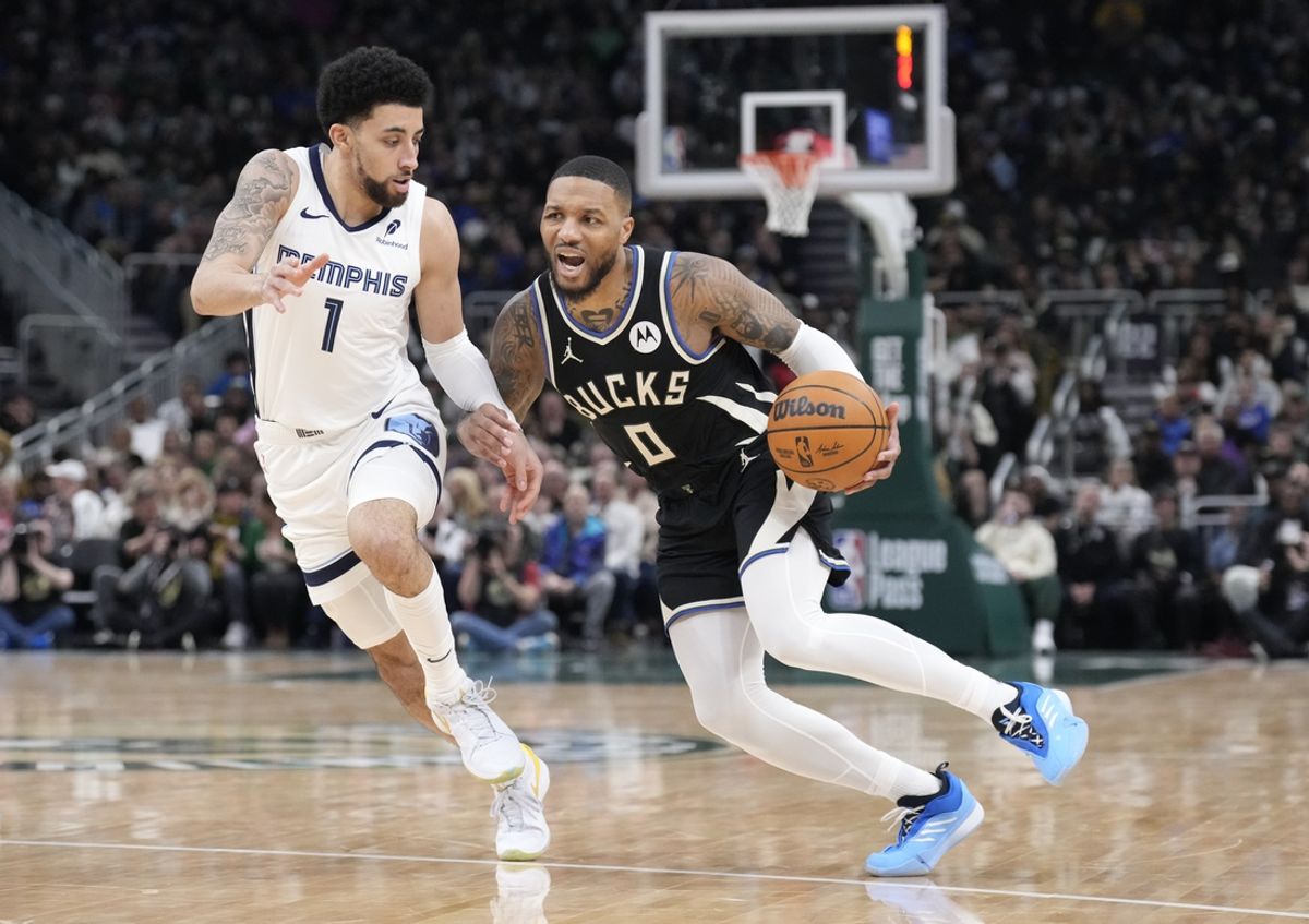 Feb 2, 2025; Milwaukee, Wisconsin, USA; Milwaukee Bucks guard Damian Lillard (0) drives to the basket against Memphis Grizzlies guard Scotty Pippen Jr. (1) in the first half at Fiserv Forum. Mandatory Credit: Michael McLoone-Imagn Images