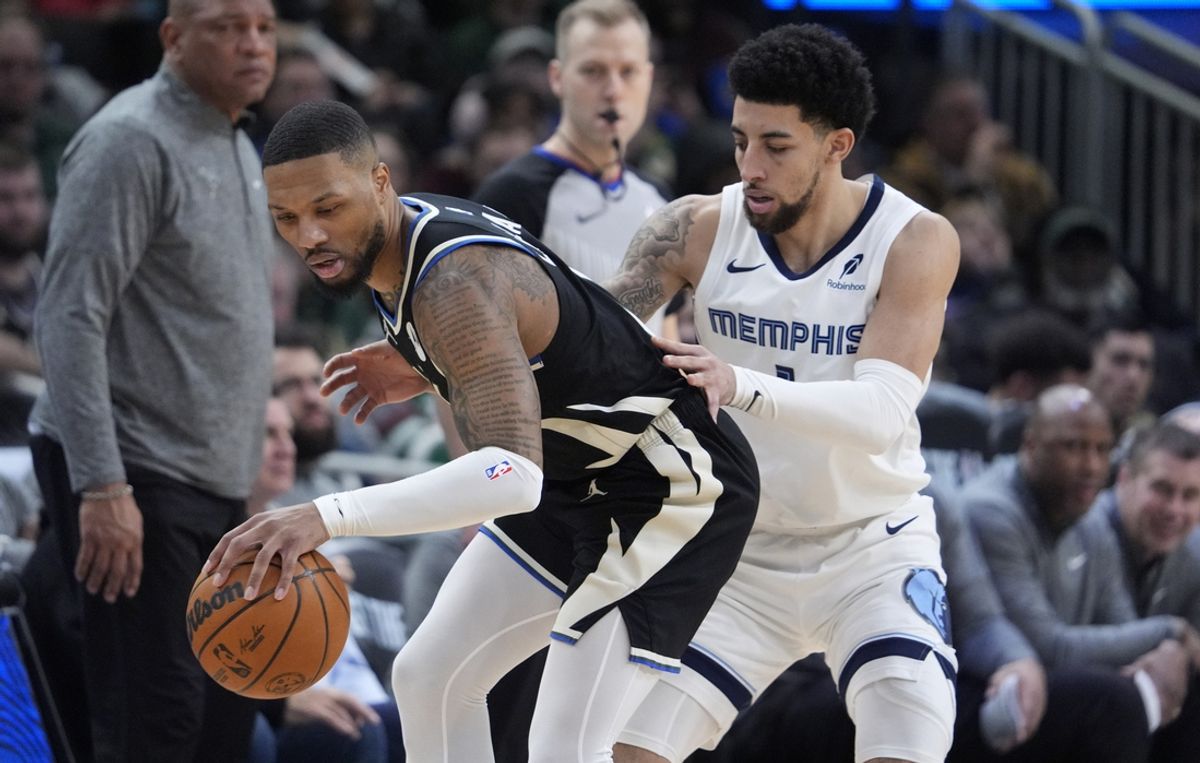Feb 2, 2025; Milwaukee, Wisconsin, USA; Milwaukee Bucks guard Damian Lillard (0) dribbles the ball against Memphis Grizzlies guard Scotty Pippen Jr. (1) in the second half at Fiserv Forum. Mandatory Credit: Michael McLoone-Imagn Images
