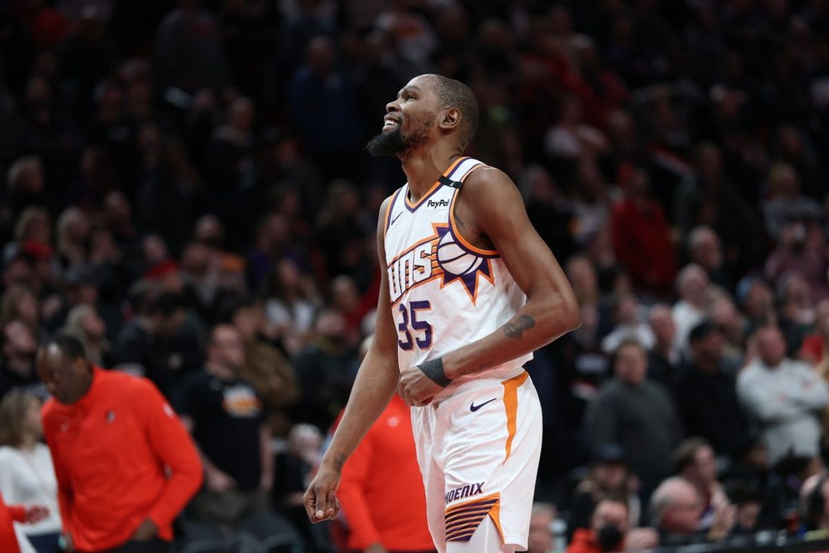 Feb 3, 2025; Portland, Oregon, USA;  Phoenix Suns forward Kevin Durant (35) laughs as he watches a replay of his teammate Suns’ guard Devin Booker (1) being fouled by Portland Trail Blazers forward Deni Avdija (8) in overtime at Moda Center. Mandatory Credit: Jaime Valdez-Imagn Images