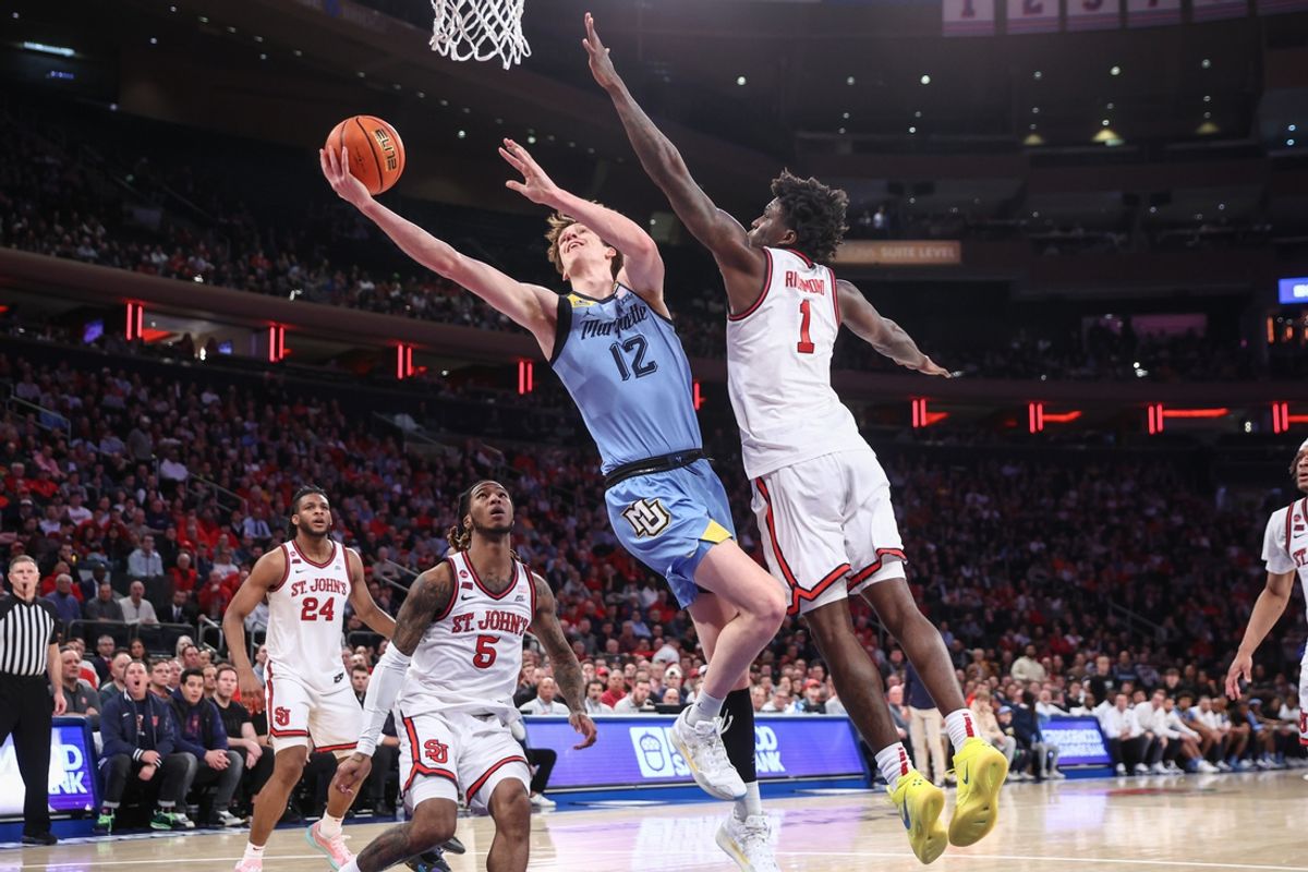 Feb 4, 2025; New York, New York, USA;  Marquette Golden Eagles forward Ben Gold (12) drives past St. John's Red Storm guard Kadary Richmond (1) in the first half at Madison Square Garden. Mandatory Credit: Wendell Cruz-Imagn Images