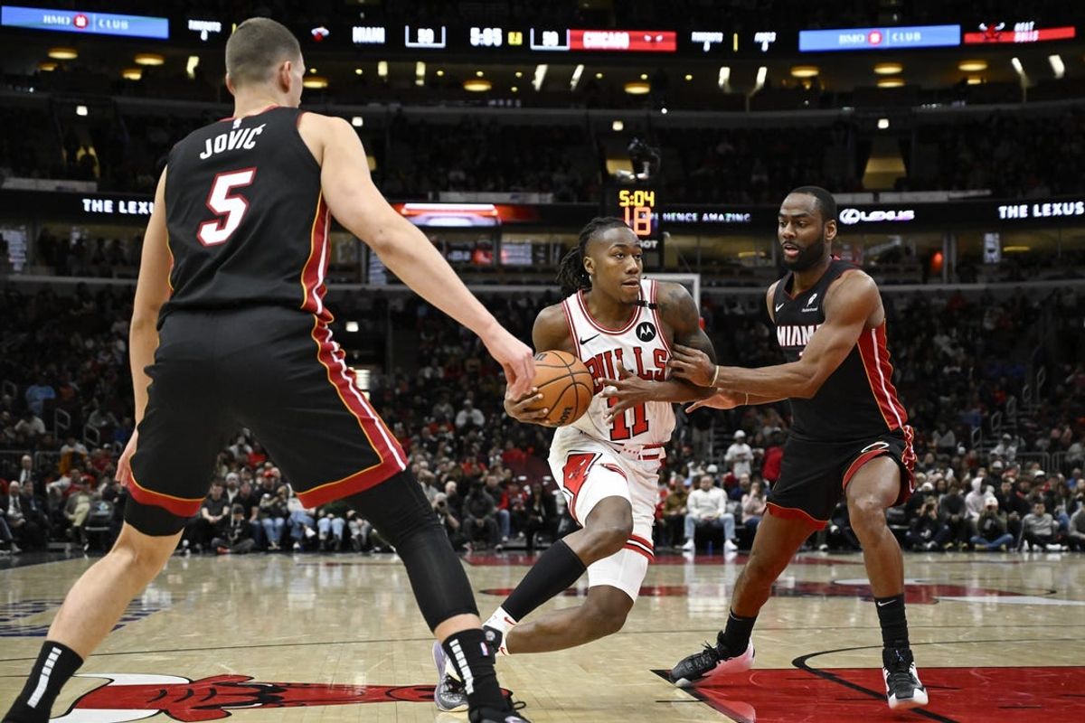 Feb 4, 2025; Chicago, Illinois, USA;  Chicago Bulls guard Ayo Dosunmu (11) moves the ball past the Miami Heat defense  during the first half at United Center. Mandatory Credit: Matt Marton-Imagn Images