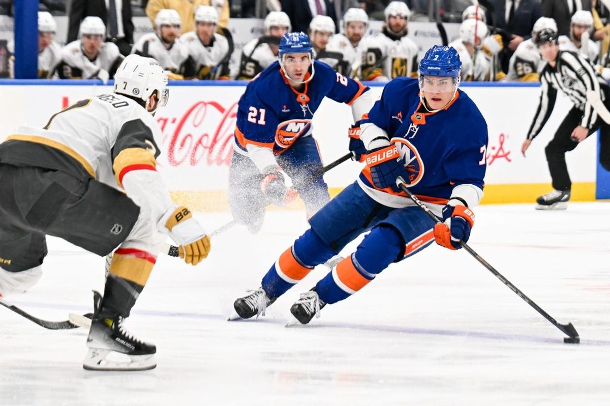 Feb 4, 2025; Elmont, New York, USA;  New York Islanders right wing Maxim Tsyplakov (7) skate across the blue line defended by Vegas Golden Knights defenseman Alex Pietrangelo (7) during the second period at UBS Arena. Mandatory Credit: Dennis Schneidler-Imagn Images