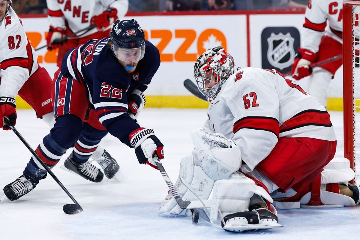 Feb 4, 2025; Winnipeg, Manitoba, CAN;  Carolina Hurricanes goalie Pyotr Kocketkov (52) makes a save on Winnipeg Jets forward Mason Appleton (22) during the second period at Canada Life Centre. Mandatory Credit: Terrence Lee-Imagn Images