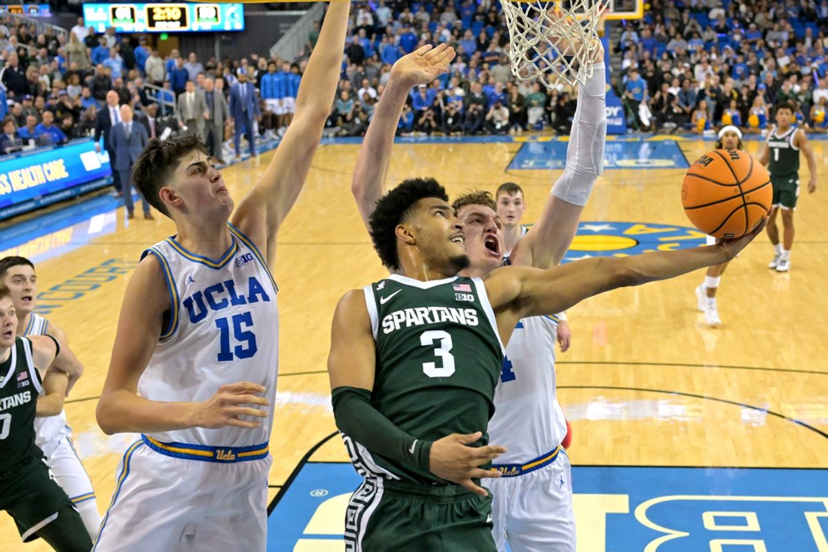 Feb 4, 2025; Los Angeles, California, USA; Michigan State Spartans guard Jaden Akins (3) scores past the defense of UCLA Bruins center Aday Mara (15) and forward Tyler Bilodeau (34) in the second half at Pauley Pavilion presented by Wescom. Mandatory Credit: Jayne Kamin-Oncea-Imagn Images