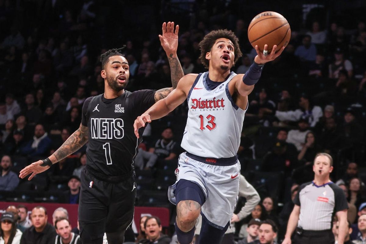 Feb 5, 2025; Brooklyn, New York, USA;  Washington Wizards guard Jordan Poole (13) drives past Brooklyn Nets guard D'Angelo Russell (1) for a layup in the first quarter at Barclays Center. Mandatory Credit: Wendell Cruz-Imagn Images